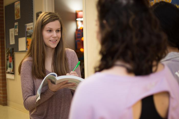 A behavioral studies student interviewing two other students